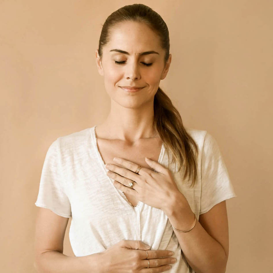 Lauren Eckstrom meditates with one hand on her heart and the other resting on her diaphragm. 